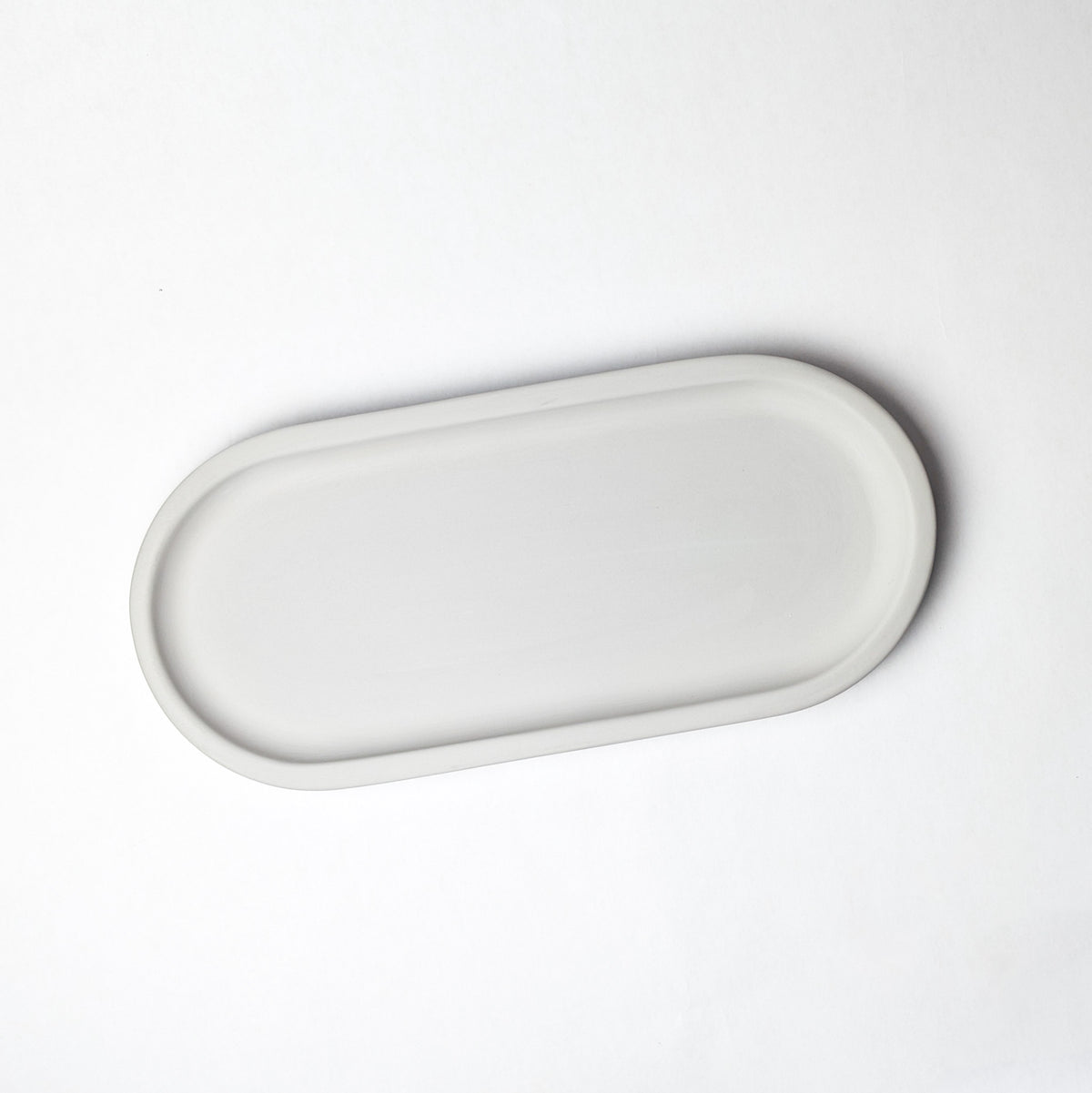 Overhead view of an oval light-gray stone tray.