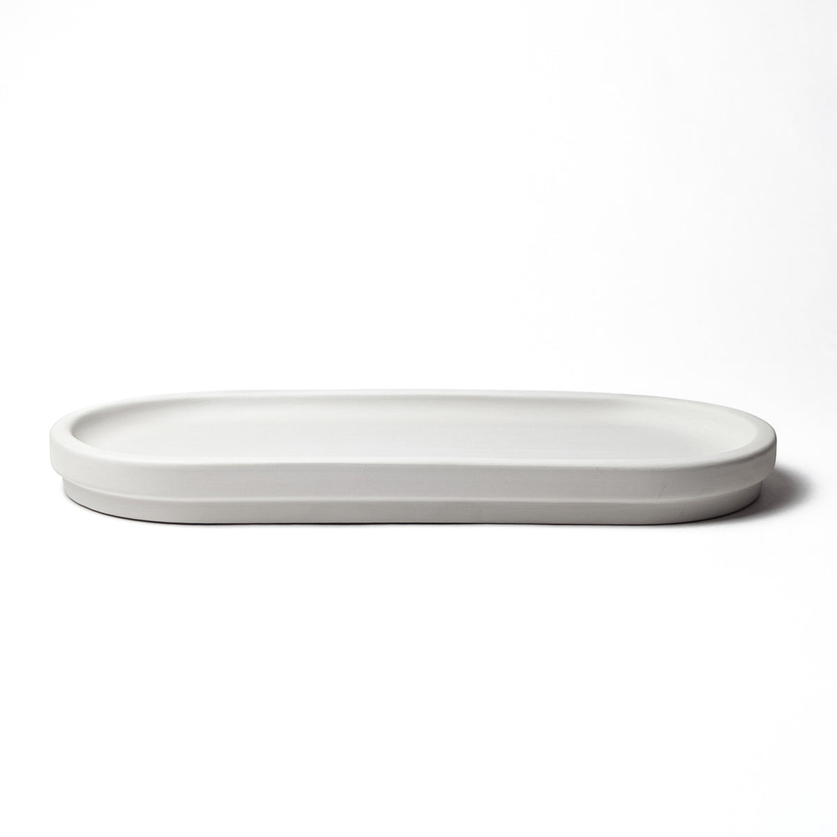 Low oval light-gray stone tray with a raised rim.